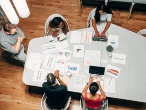 Group of professionals collaborating at a table with marketing charts and data, illustrating effective strategies for business growth and email marketing.
